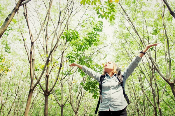 Красивая молодая женщина с рюкзаком прогулки в лесу изюм — стоковое фото