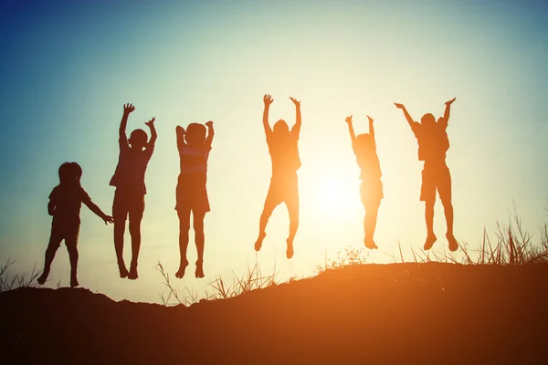 Silhouet van kinderen springen van blijdschap gelukkig tijd — Stockfoto