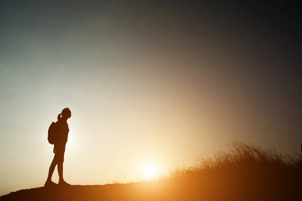 Silhouet van de vrouw backpacken met zonsondergang. — Stockfoto