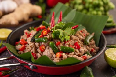 Kızarmış domuz fesleğeni ve muz yaprakları kızartma tavasında. Tayland yemeği..