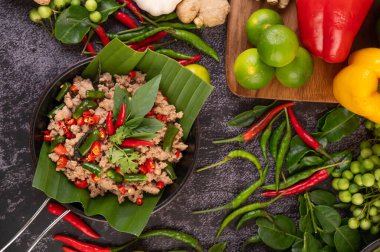Kızarmış domuz fesleğeni ve muz yaprakları kızartma tavasında. Tayland yemeği..