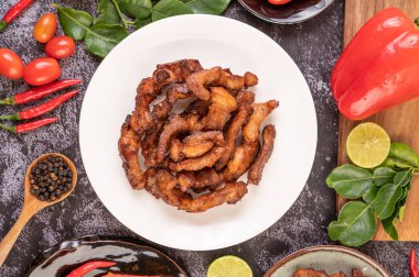 Biber tohumlu domuz pirzolası, kaffir limon yaprağı, limon, biber, siyah çimentoda sarımsak..