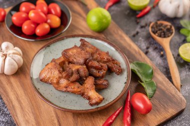 Biber tohumlu domuz pirzolası, kaffir limon yaprağı, limon, biber, siyah çimentoda sarımsak..