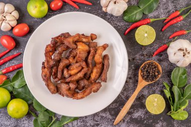 Biber tohumlu domuz pirzolası, kaffir limon yaprağı, limon, biber, siyah çimentoda sarımsak..