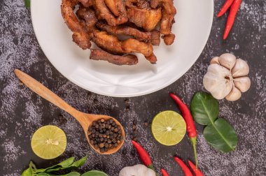 Biber tohumlu domuz pirzolası, kaffir limon yaprağı, limon, biber, siyah çimentoda sarımsak..