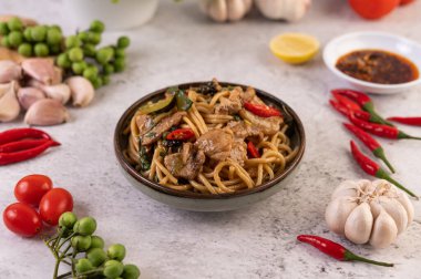 Spagettiyi kızart, domuz etini biber, biber, sarımsak, domates, marul, limon ve fesleğenle bir kaseye koy..