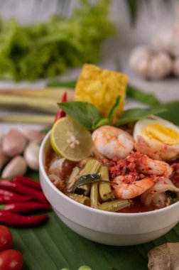 Limon, salatalık, fesleğen, patlıcan ve sarımsak eşliğinde karides ve haşlanmış yumurtalı Tom Yum noodle..