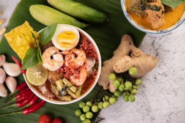 Limon, salatalık, fesleğen, patlıcan ve sarımsak eşliğinde karides ve haşlanmış yumurtalı Tom Yum noodle..