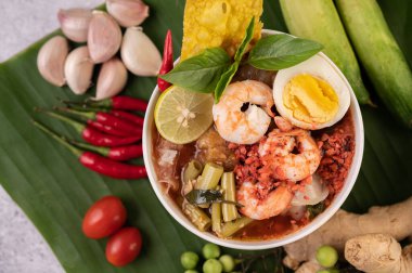 Limon, salatalık, fesleğen, patlıcan ve sarımsak eşliğinde karides ve haşlanmış yumurtalı Tom Yum noodle..