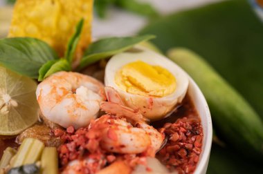 Limon, salatalık, fesleğen, patlıcan ve sarımsak eşliğinde karides ve haşlanmış yumurtalı Tom Yum noodle..