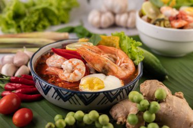 Limon, salatalık, fesleğen, patlıcan ve sarımsak eşliğinde karides ve haşlanmış yumurtalı Tom Yum noodle..