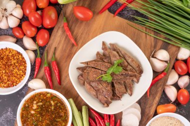 Beyaz tabakta ızgara domuz ciğeri, domates, sarımsak, fasulye ve sos..