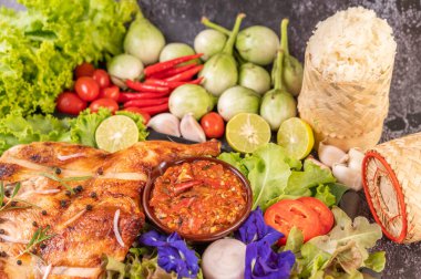 Tabakta ızgara tavuk, pilav, biber, sarımsak sosu ve üzerine biber tohumu serpiştirilmiş.