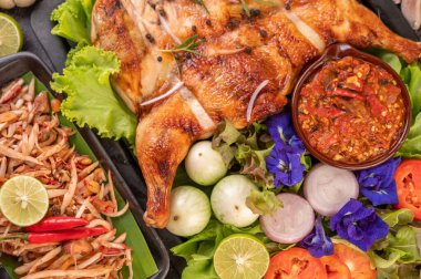 Biberli ızgara tavuk, sarımsak sosu ve biber çekirdeği serpiştirilmiş..