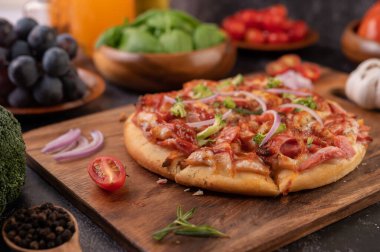 Biber tohumlarıyla dolu tahta bir tabağa yerleştirilmiş pizza. Domates ve sarımsak. Seçici odak.