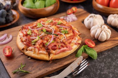 Biber tohumlarıyla dolu tahta bir tabağa yerleştirilmiş pizza. Domates ve sarımsak. Seçici odak.