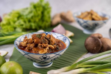 Seramik kasede tatlı domuz eti, muz yaprağında geyik, taze soğan, mantar ve limon..