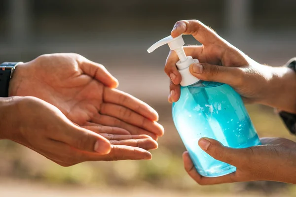 Hands at the gel bottle to wash hands and squeeze for others to wash hands.