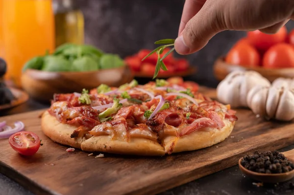Biber tohumlarıyla dolu tahta bir tabağa yerleştirilmiş pizza. Domates ve sarımsak. Seçici odak.