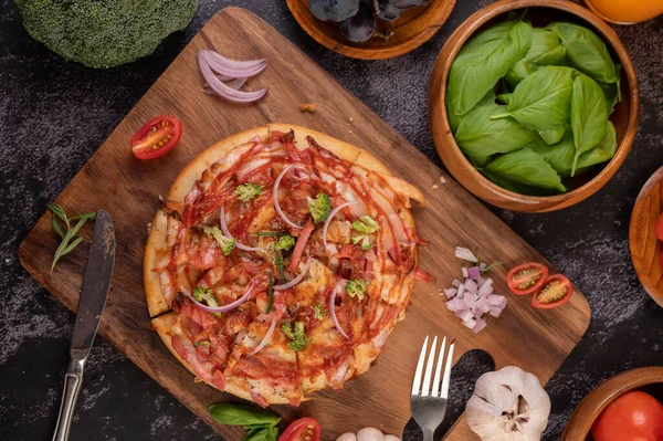 Biber tohumlarıyla dolu tahta bir tabağa yerleştirilmiş pizza. Domates ve sarımsak. Üst görünüm.