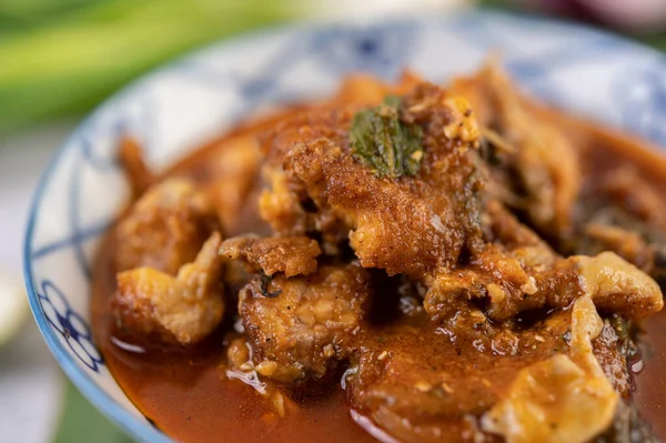 Muz yaprağına seramik bir kaptaki tatlı domuz eti.