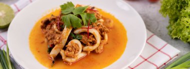 Beyaz tabakta köri tozu ile karıştırılmış kalamar..