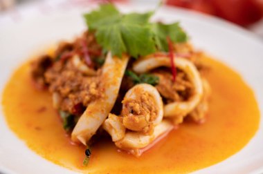 Beyaz tabakta köri tozu ile karıştırılmış kalamar..