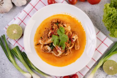 Beyaz tabakta köri tozu ile karıştırılmış kalamar..