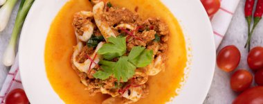 Beyaz tabakta köri tozu ile karıştırılmış kalamar..