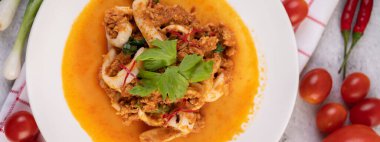 Beyaz tabakta köri tozu ile karıştırılmış kalamar..