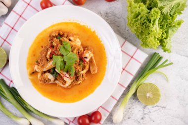 Beyaz tabakta köri tozu ile karıştırılmış kalamar..