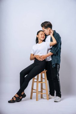 İki kadın aşık birbirlerine sarılıp bir sandalyeye oturdular..