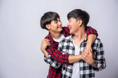 Birbirini seven iki adam birbirine sarılır..