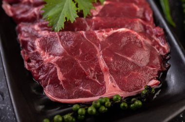 Çili, domates, fesleğen ve taze biber tohumlarıyla pişirmek için dilimlenmiş çiğ domuz eti..