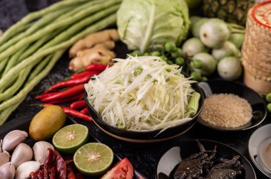 Papaya salatası malzemeleri arasında papaya, turşulu yengeç, patlıcan, domates, ıhlamur, biber, sarımsak ve mayalanmış balık yer alıyor..