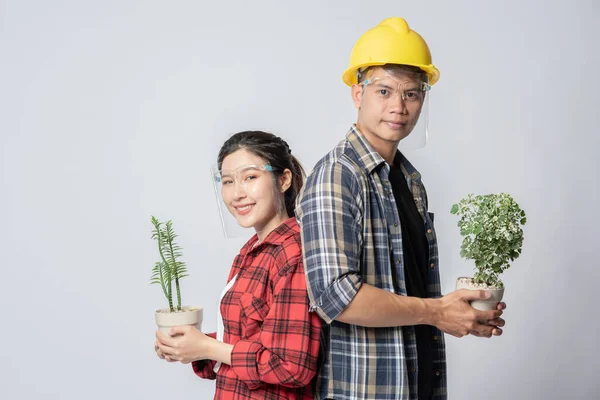 家の中に植物のポットを立っている男性と女性 — ストック写真