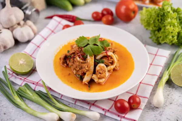 Beyaz tabakta köri tozu ile karıştırılmış kalamar..