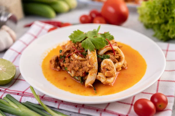 Beyaz tabakta köri tozu ile karıştırılmış kalamar..