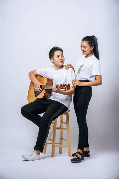 Dwie Młode Kobiety Usiadły Krześle Grały Gitarze — Zdjęcie stockowe