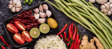 Papaya salatası malzemeleri arasında papaya, turşulu yengeç, patlıcan, domates, ıhlamur, biber, sarımsak ve mayalanmış balık yer alıyor..