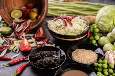 Papaya salatası malzemeleri arasında papaya, turşulu yengeç, patlıcan, domates, ıhlamur, biber, sarımsak ve mayalanmış balık yer alıyor..