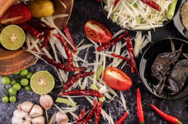 Papaya salatası malzemeleri arasında papaya, turşulu yengeç, patlıcan, domates, ıhlamur, biber, sarımsak ve mayalanmış balık yer alıyor..