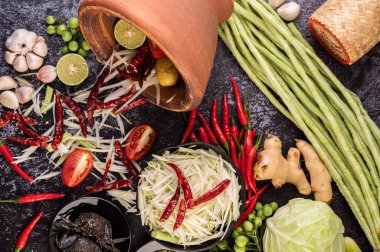 Papaya salatası malzemeleri arasında papaya, turşulu yengeç, patlıcan, domates, ıhlamur, biber, sarımsak ve mayalanmış balık yer alıyor..