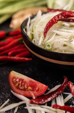 Papaya salatası malzemeleri arasında papaya, turşulu yengeç, patlıcan, domates, ıhlamur, biber, sarımsak ve mayalanmış balık yer alıyor..