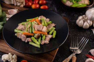 Kızarmış lahana ve ahşap bir tabakta domuz göbeği..