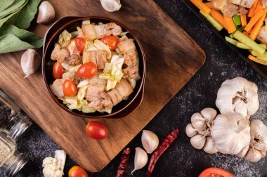 Tahta bir tabakta domuz göbeğiyle lahana karıştır..