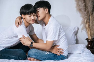 Birbirini seven iki genç adam kucaklaştı ve güzel kokulu yanaklar kokladı..