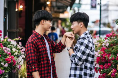 İki sevgili genç adam gömlekli ve kaldırımda dikiliyorlar..