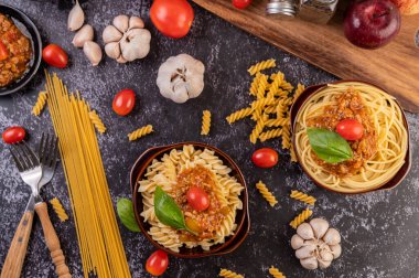 Domatesli makarna ve gri tabakta fesleğen..