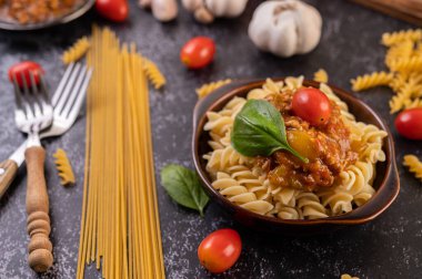 Domatesli makarna ve gri tabakta fesleğen..